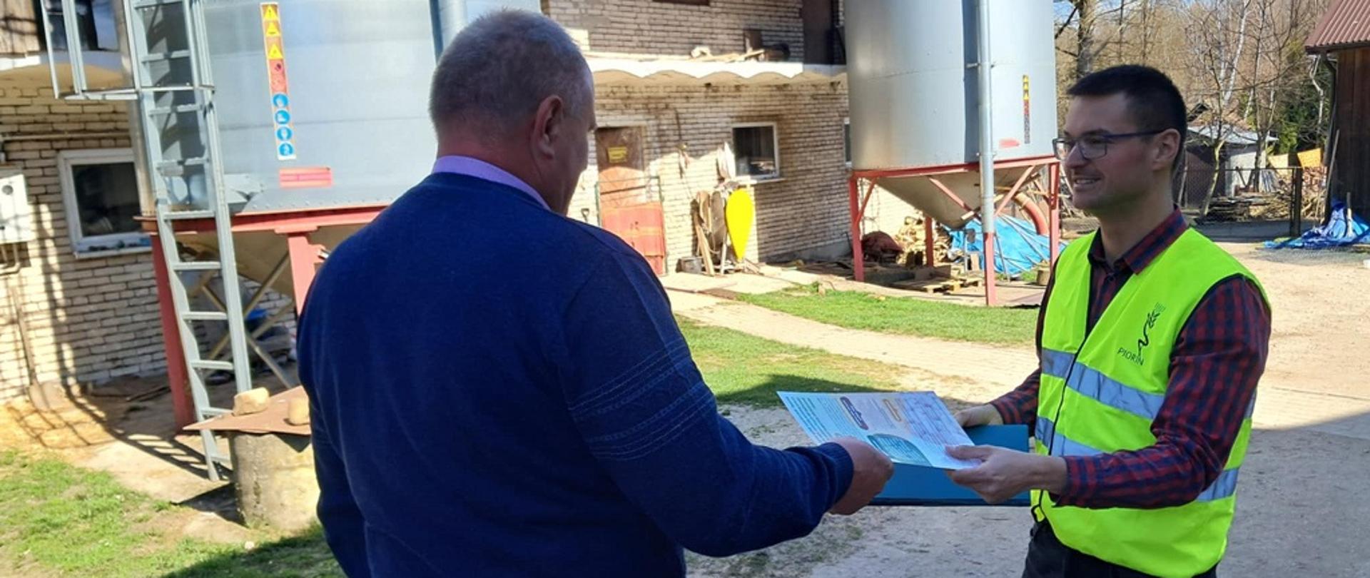 Inspektor WIORiN przekazuje materiały informacyjne dotyczące obniżonych opłat za pobranie prób i badania laboratoryjne ziemniaków, którymi rolnicy planują obsadzić swoje plantacje, jednemu z producentów bulw ziemniaków z powiatu kazimierskiego. 