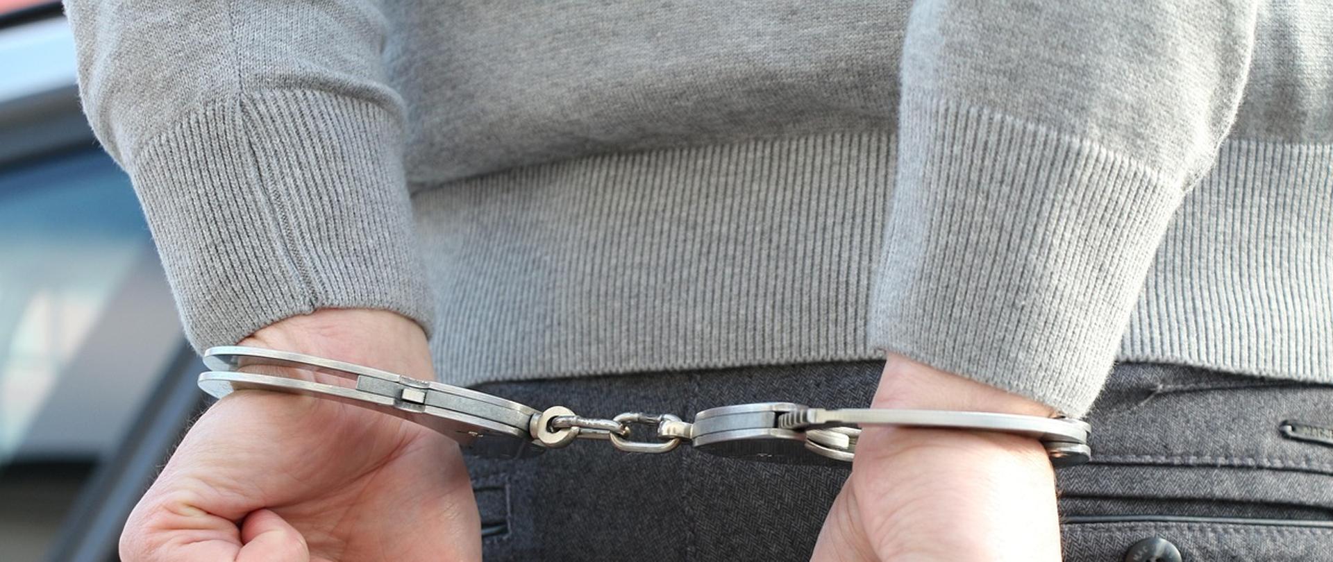 Dłonie w kajdankach.