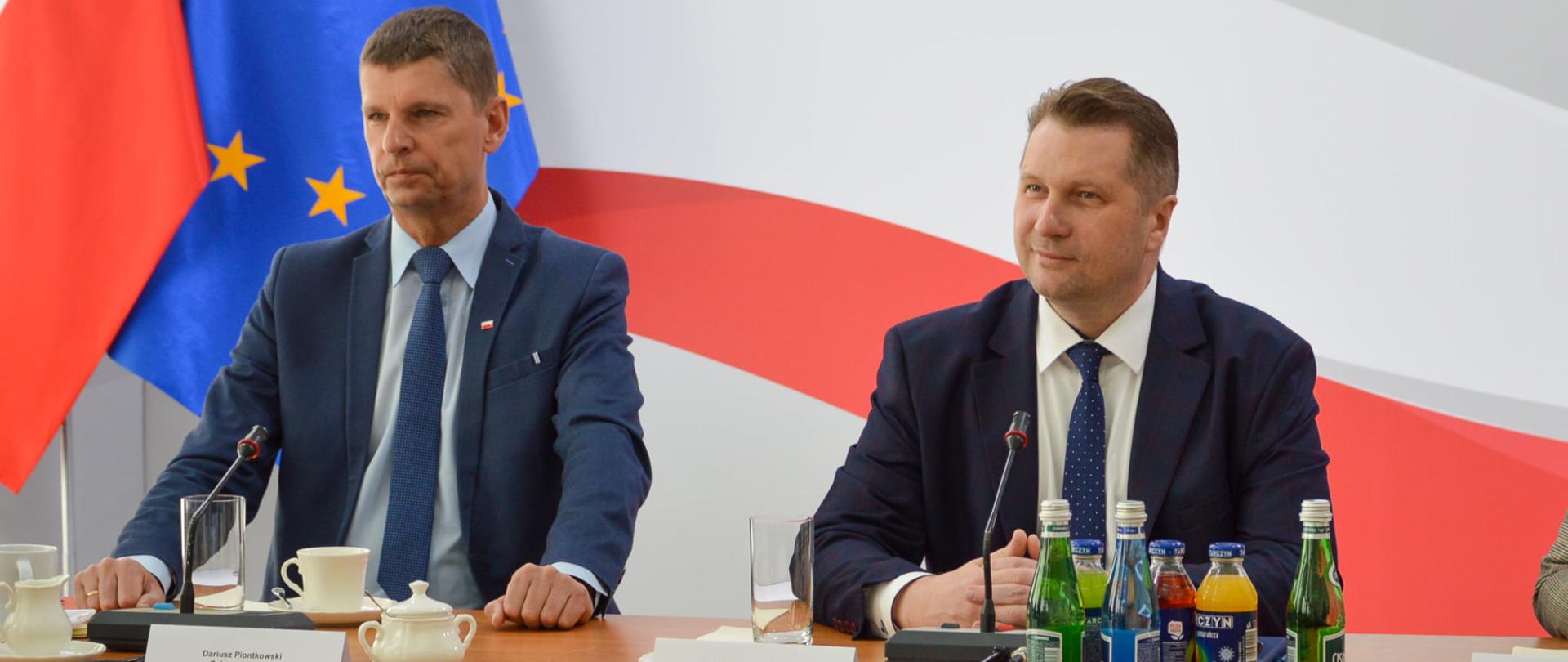 Minister Przemysław Czarnek i wiceminister Dariusz Piontkowski siedzą przy stole podczas spotkania