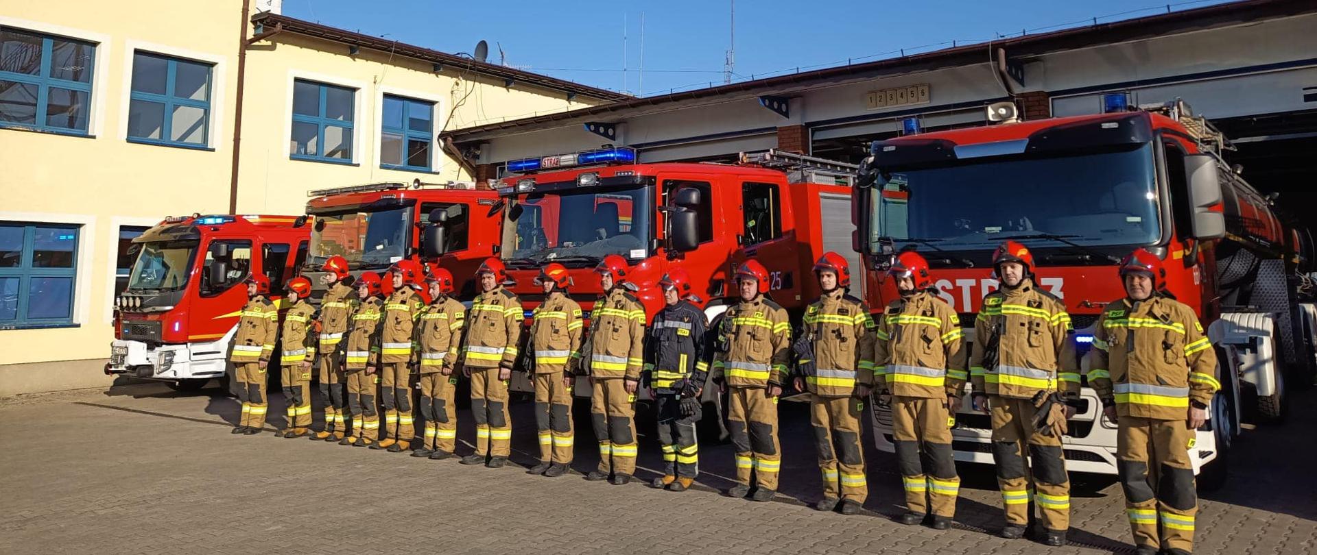 Strażacy stojący przed samochodami a samochody stoją przed garażami w szyku reprezentatywnym