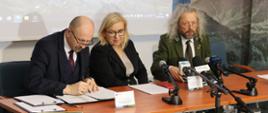 Zdjęcie z uroczystości podpisania umowy o dofinansowanie dla TPN. Od lewej siedzą: zastępca prezesa NFOŚiGW Robert Gajda, ministra klimatu i środowiska Paulina Hennig-Kloska i Dyrektor Tatrzańskiego Parku Narodowego Szymon Ziobrowski