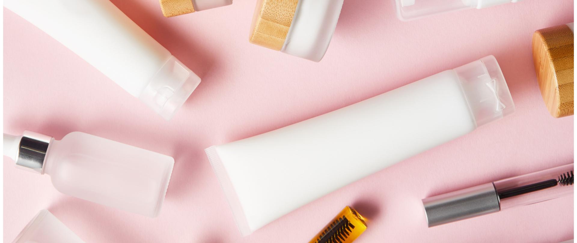 Na zdjęciu są kosmetyki. Tło jest różowe.
