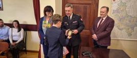 Komendanta Straży, Pani Starosta i Burmistrz Pniew wręczają odznaczenie bohaterowi