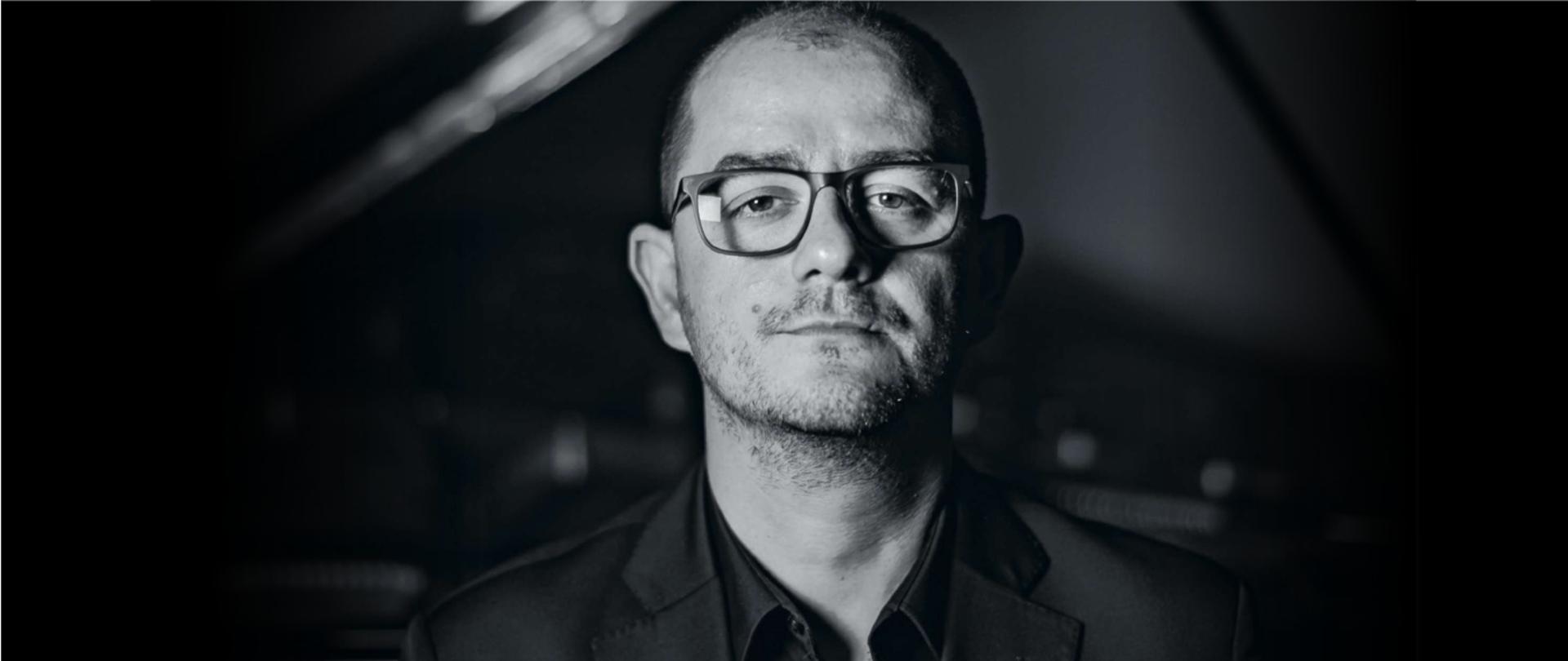 Zdjęcie przedstawia Michała Francuza na tle fortepianu