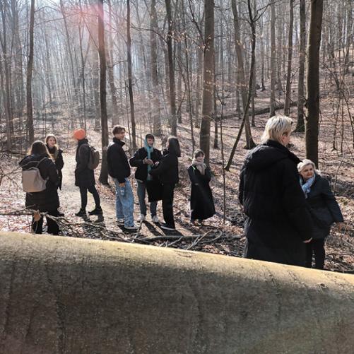 Zdjęcie przedstawia grupę uczniów wraz z nauczycielką na tle drzew podczas wycieczki w lesie, inne ujęcie