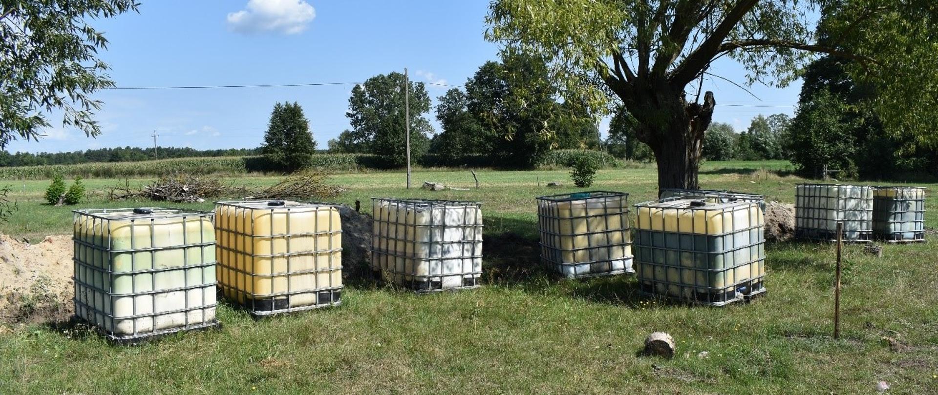 Klika zbiorników o pojemności 1000 l stoi na otwartym terenie.