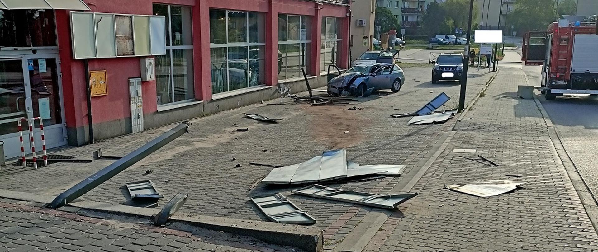 Miejsce w którym samochód osobowy zniszczył baner reklamowy i uderzył w ścianę sklepu