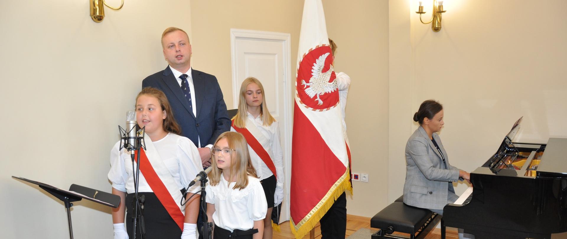 Śpiewanie hymnu szkoły podczas uroczystości rozpoczęcia roku szkolnego.