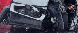 ZDJĘCIE PRZEDSTAWIA SAMOCHÓD DOSTAWCZY, KTÓRY UDERZYŁ W PRZYDROŻNE DRZEWO ORAZ NARZĘDZIA HYDRAULICZNE, KTÓRYMI STRAŻACY WYKONYWALI DOSTĘP DO POSZKODOWANEGO