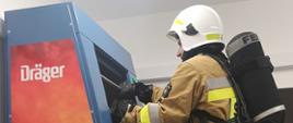 Na zdjęciu strażak w umundurowaniu specjalnym podczas testu na drabinie bez końca