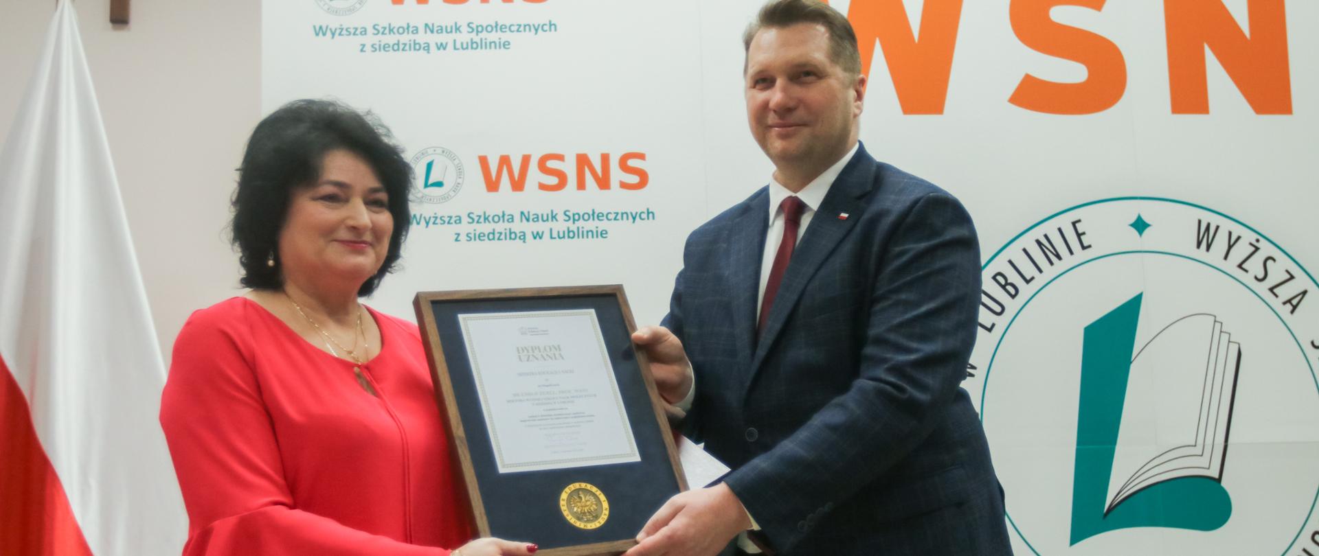 Minister wręcza dyplom kobiecie rektor uczelni