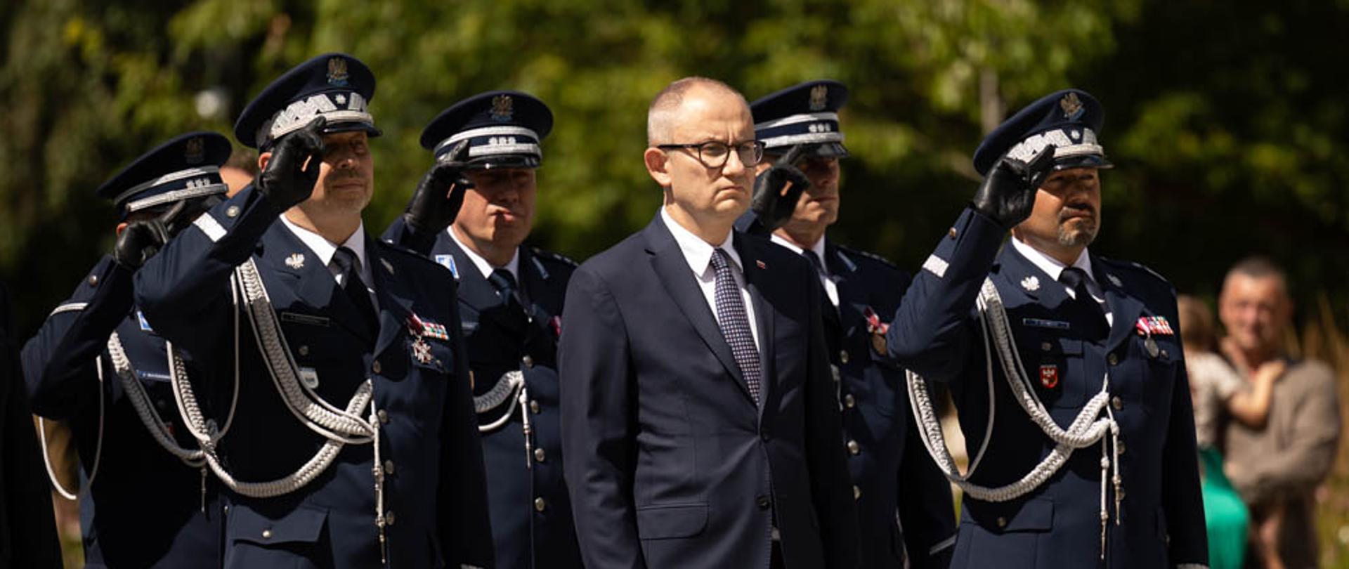 Na zdjęciu widać m. in. wiceministra Błażeja Pobożnego w trakcie wysłuchiwania hymnu narodowego. 