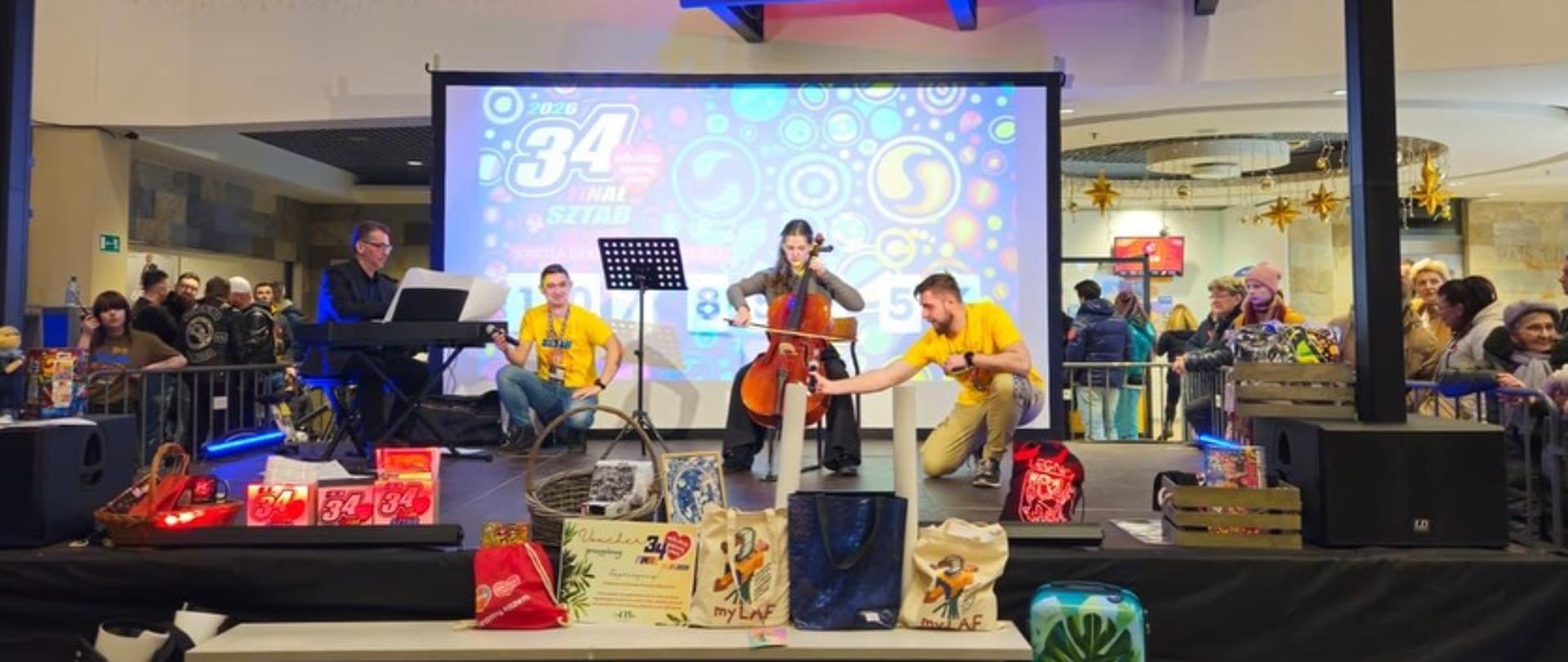Zdjęcie przedstawiające wykonawców, którzy zagrali koncert w galerii handlowej w Legnicy z okazji 34. finału Wielkiej Orkiestry Świątecznej Pomocy.