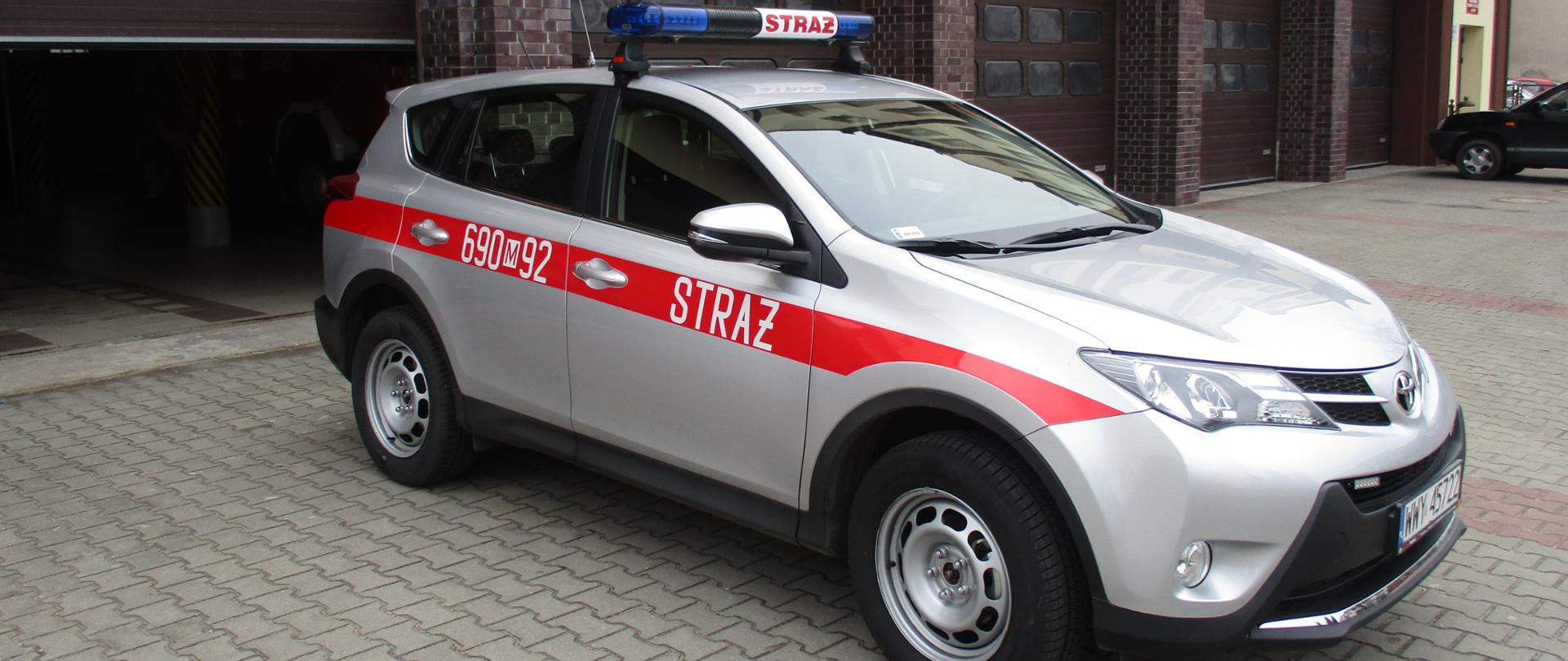 Pojazd strażacki na tle Komendy Powiatowej PSP