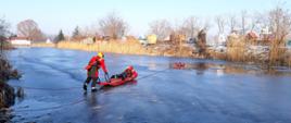 SZKOLENIE DOSKONALĄCE W ZAKRESIE RATOWNICTWA LODOWEGO. akwen wodny, pokryty warstwą lodu, strażacy ćwiczą w zakresie ratownictwa wodnego działania na zamarzniętych zbiornikach.