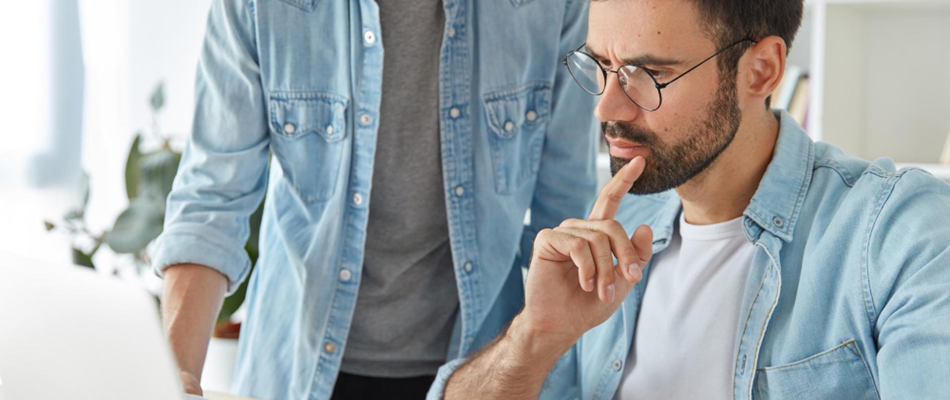 Mężczyzna przy laptopie wypełniający dokumenty