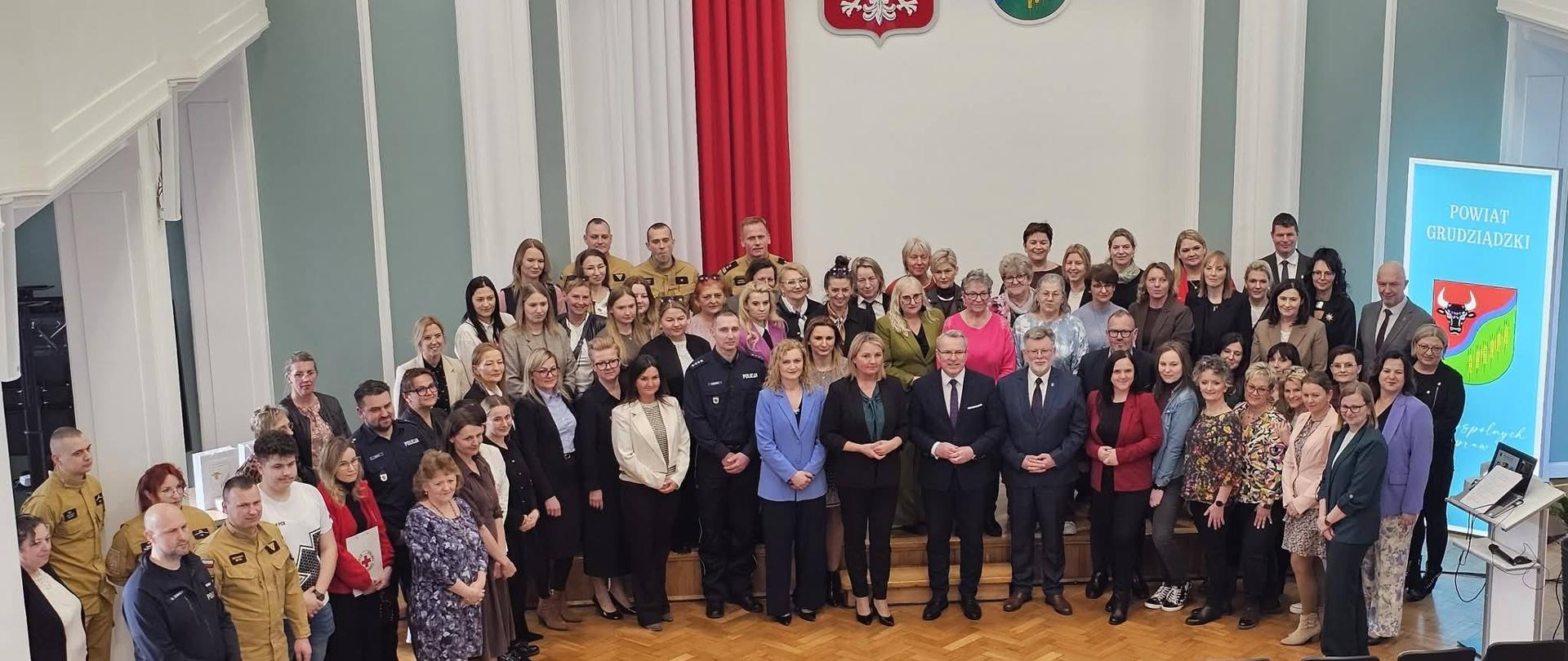 Zdjęcia grupowe kilkudziesięciu uczestników konferencji w dużej sali.