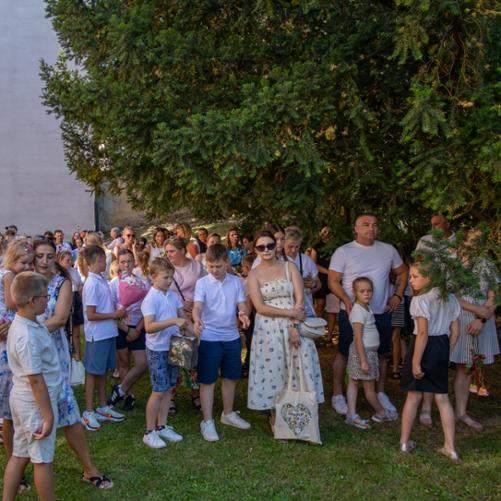 Rodzice i uczniowie zgromadzeni na szkolnym podwórku.