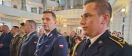 Kościół św. A. Boboli w Rawiczu. We mszy świętej uczestniczą m.in. przedstawiciele służb mundurowych: Państwowej Straży Pożarnej, Policji, Służby Więziennej i Wojska Polskiego. Funcjonariusze i żołnierze w mundurach wyjściowych stoją obok siebie. 