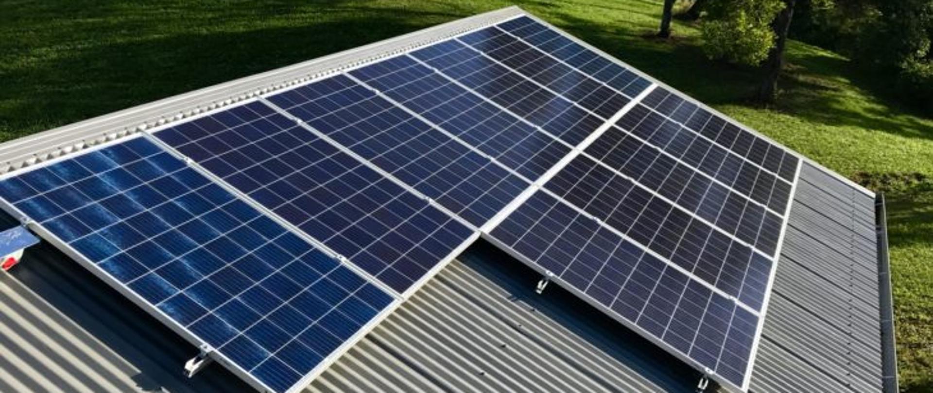 Zdjęcie przedstawia panele fotowoltaiczne na dachu budynku