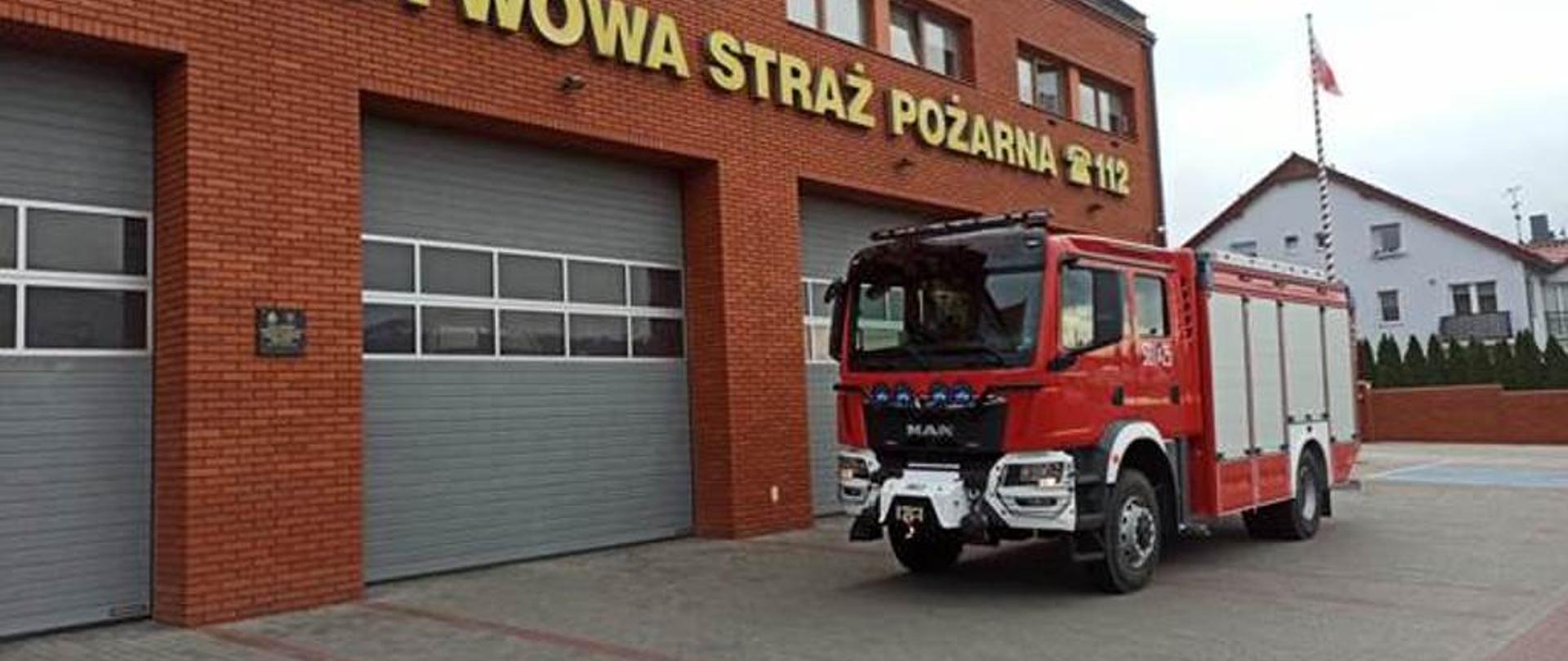 samochód strażacki na tle budynku Komendy