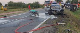 Wypadek dwóch samochodów osobowych, po lewej stronie widoczny śmigłowiec LPR, po prawej widoczne auta straży pożarnej, 