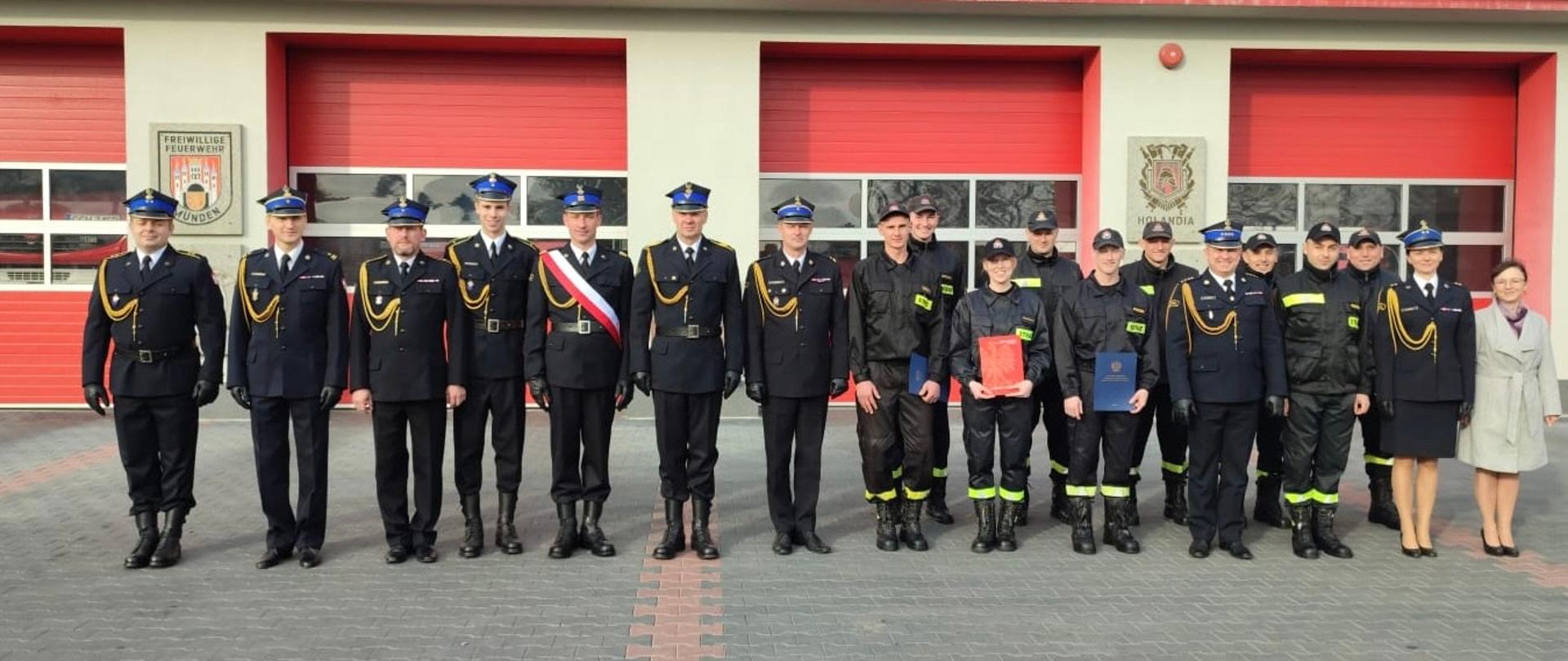 Na zdjęciu znajdują się funkcjonariusze i pracownicy cywilni komendy. Zdjęcie wykonano na placu zewnętrznym przy maszcie flagowym podczas uroczystej zbiórki z okazji Narodowego Święta Niepodległości. 