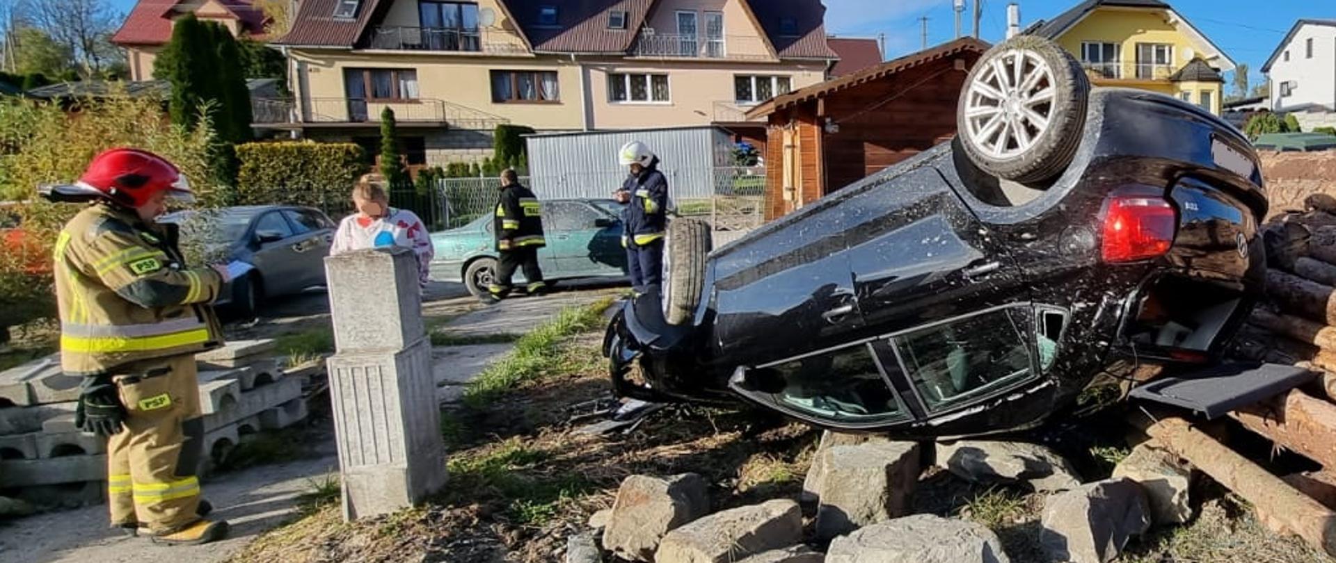 Zdjęcie przedstawia samochód osobowy stojący na dachu.