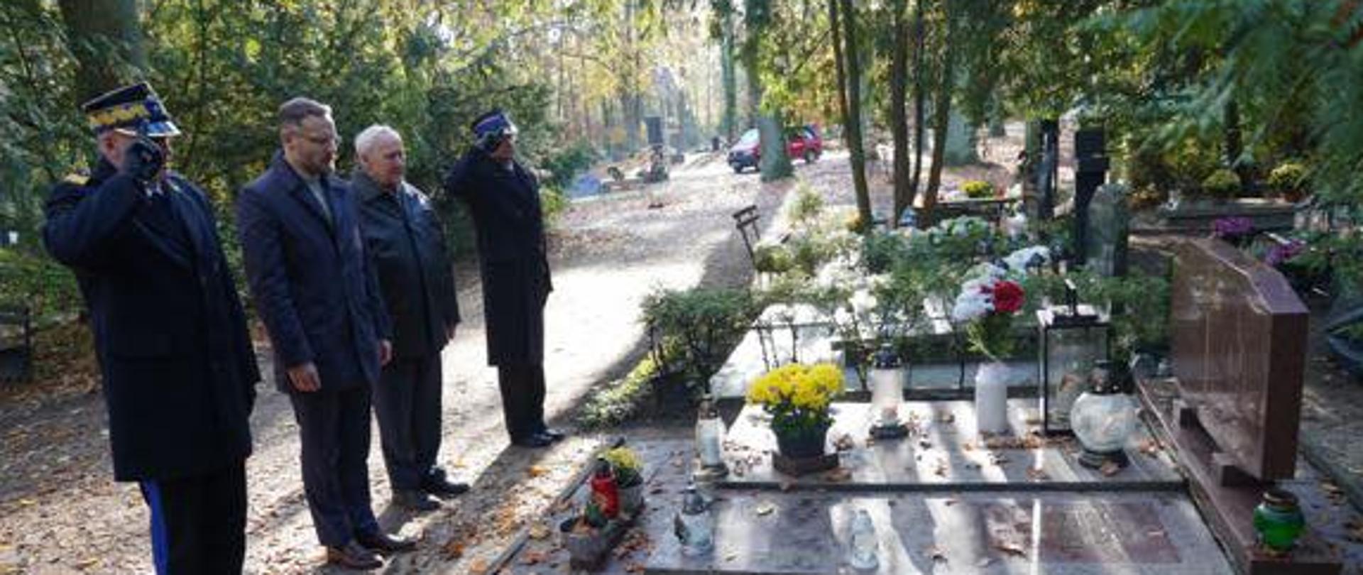 Złożenie hołdu przy grobie strażaka, 4 mężczyzn nad grobem - od lewej nadbryg. Jarosław Tomczyk, Zbigniew Bogucki, nn. ,st.bryg. Robert Tarczyński