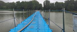 Widok na rozwiniętą linię gaśniczą przez most pływający na Jeziorze Raczyńskiego prowadzący na Wyspę Edwarda