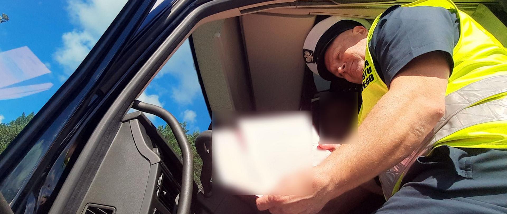 Inspektor sprawdza dokumenty kierowców litewskiego zespołu pojazdów