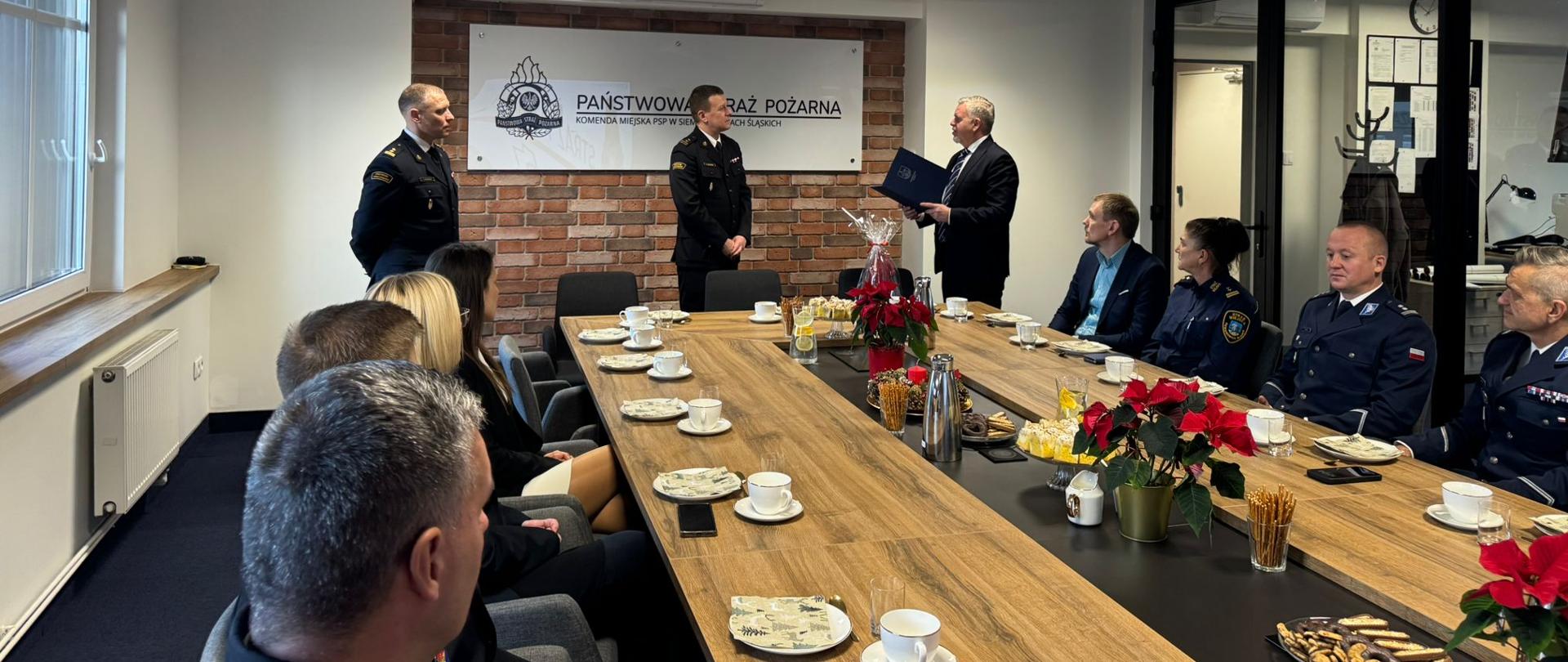 Moment wręczenia pamiątkowego upominku podczas spotkania z okazji 30-lecia funkcjonowania krajowego systemu ratowniczo-gaśniczego w Komendzie Miejskiej PSP w Siemianowicach Śląskich.