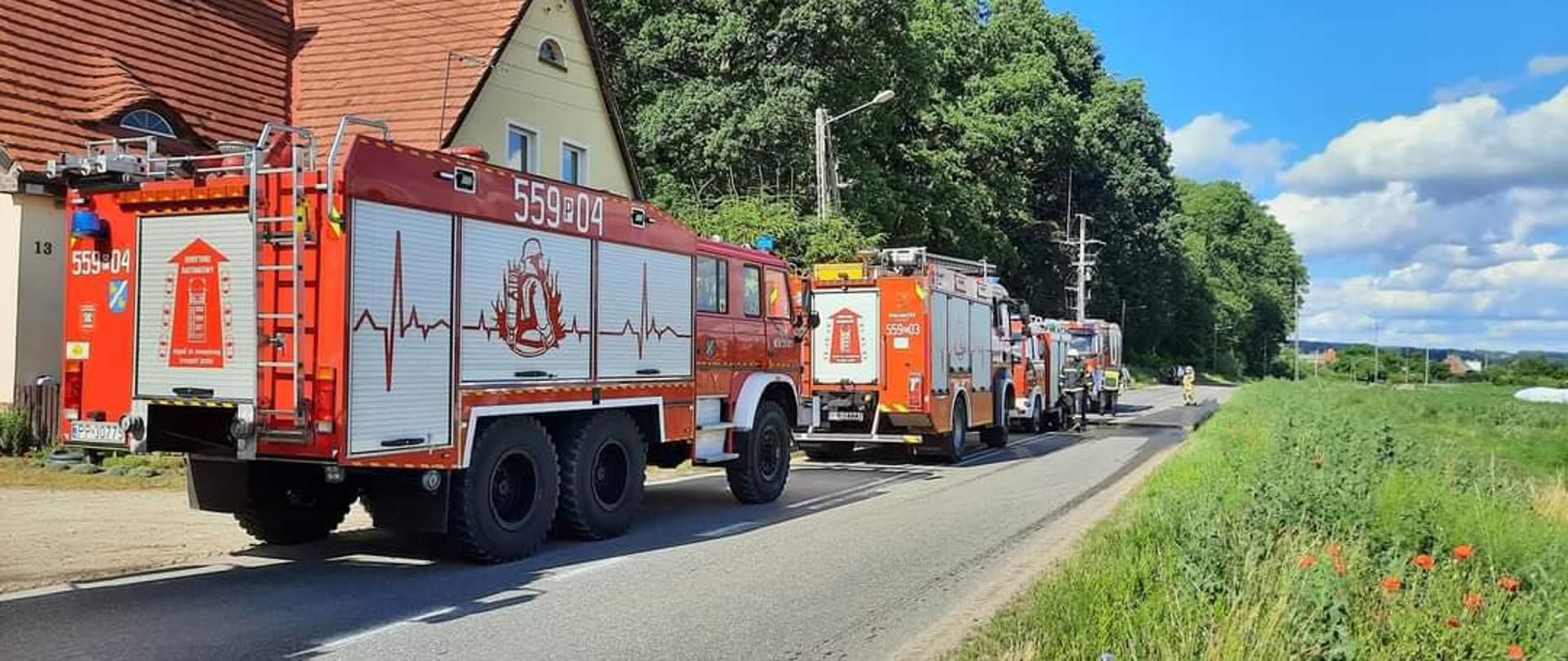 Na zdjęciu widnieją wozy strażackie podczas akcji gaszenia pożaru mieszkania. 
