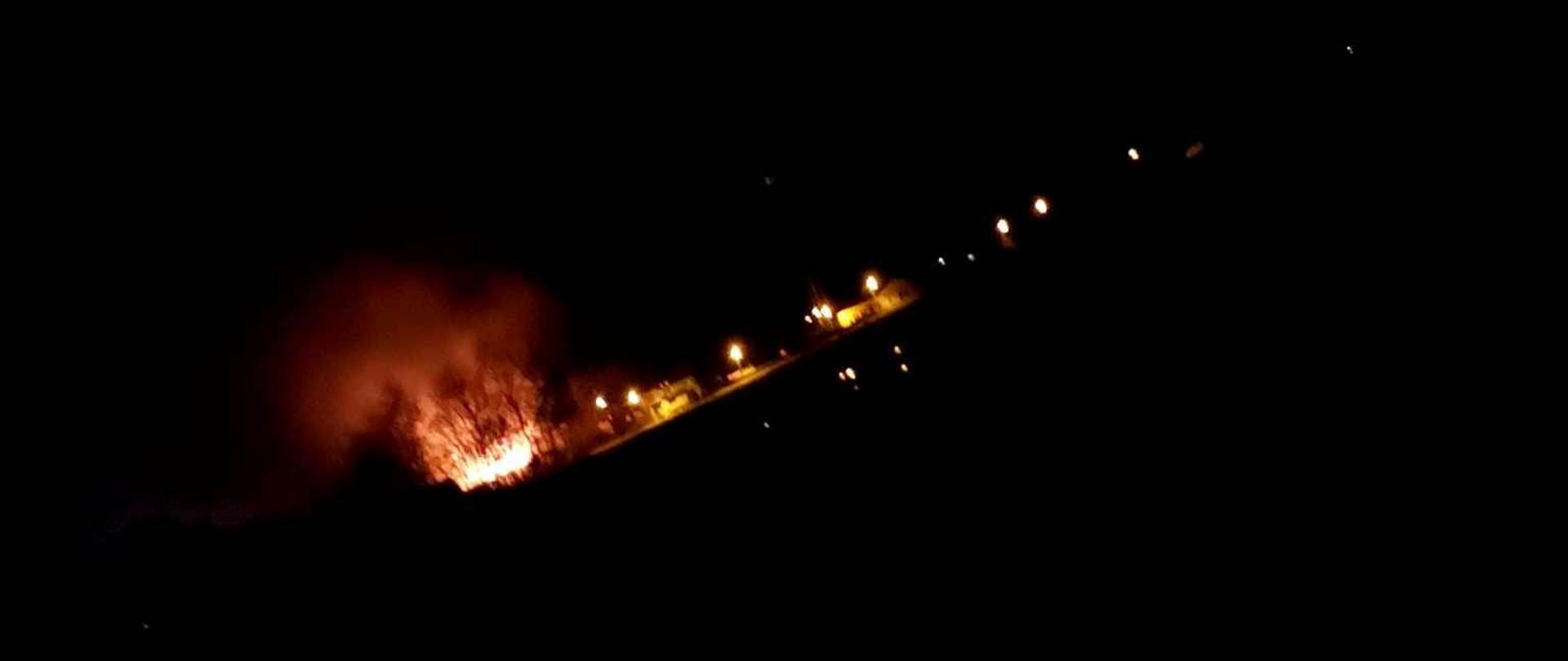 Pożar budynku, widać ogień na dachu, jest ciemno