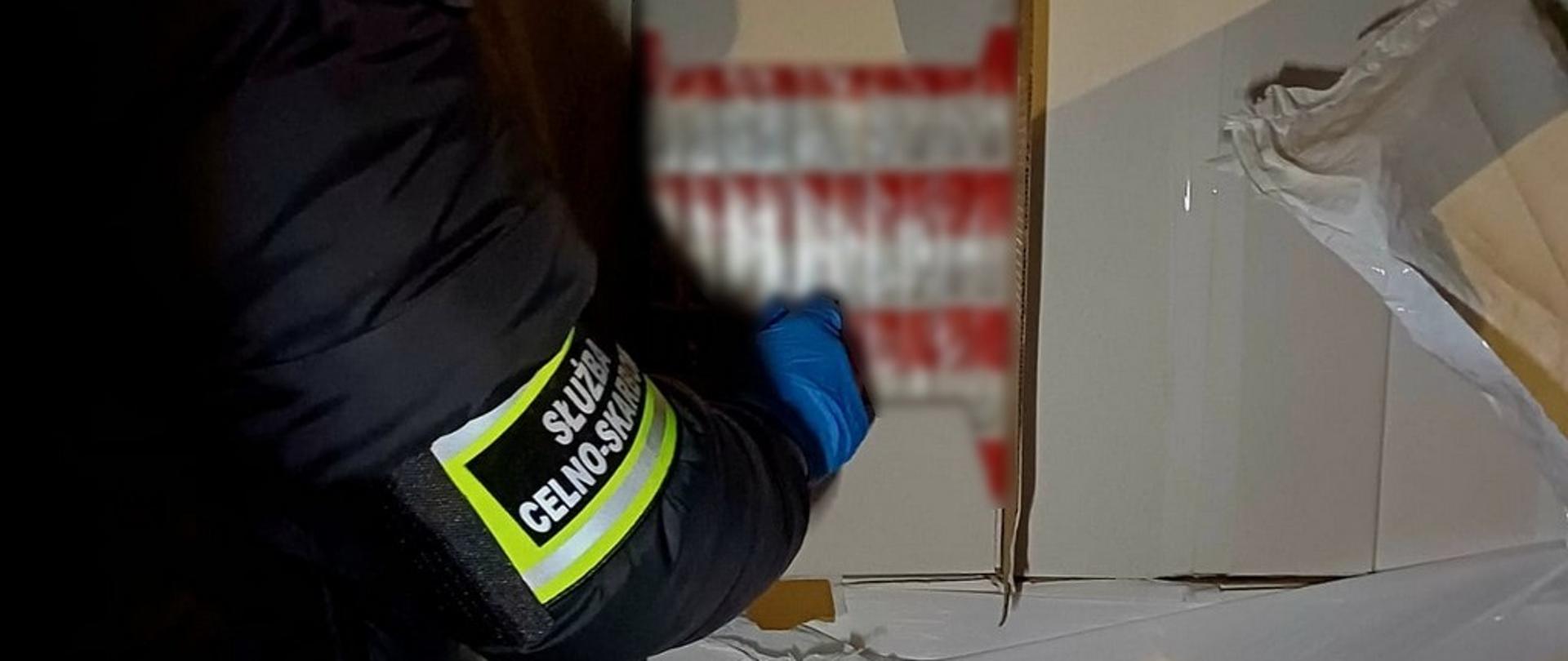 Funkcjonariusz przy zabezpieczonych papierosach