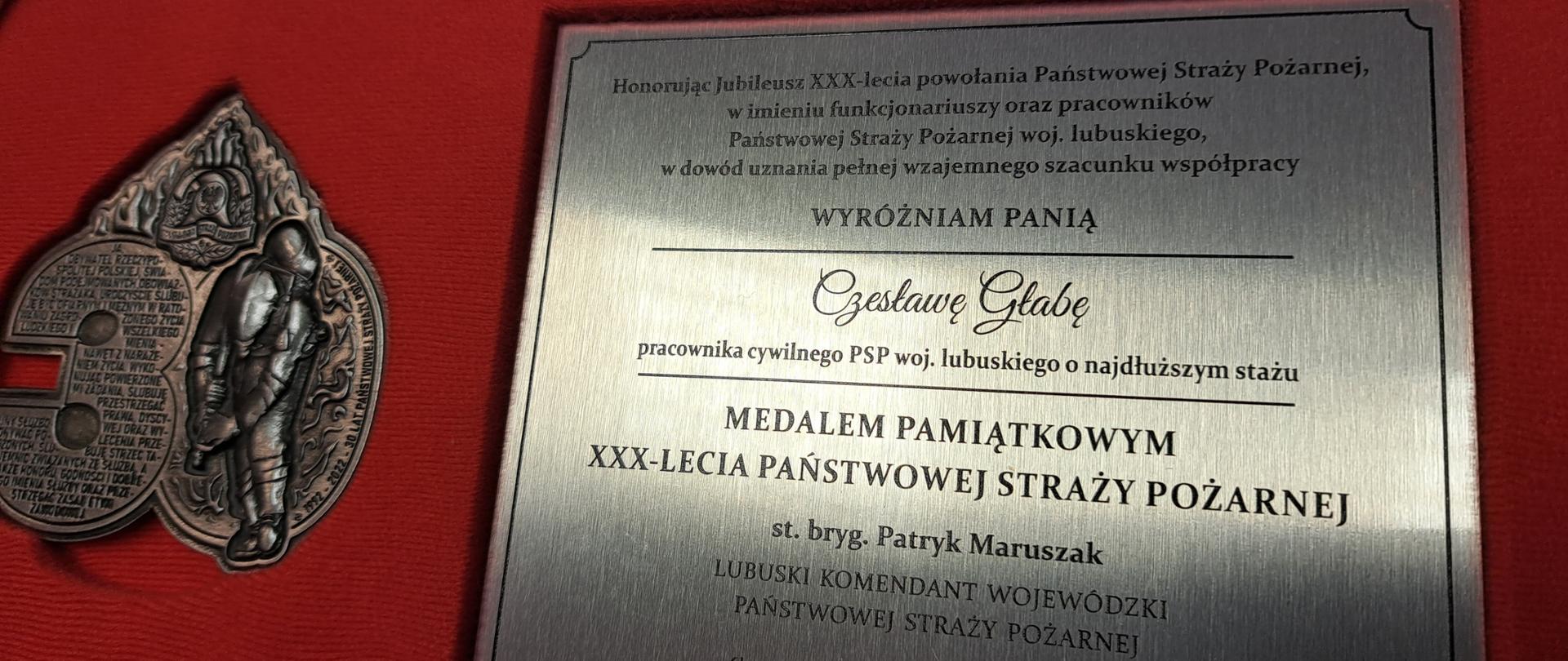 Widok tabliczki wraz z medalem pamiątkowym z okazji XXX-lecia PSP.