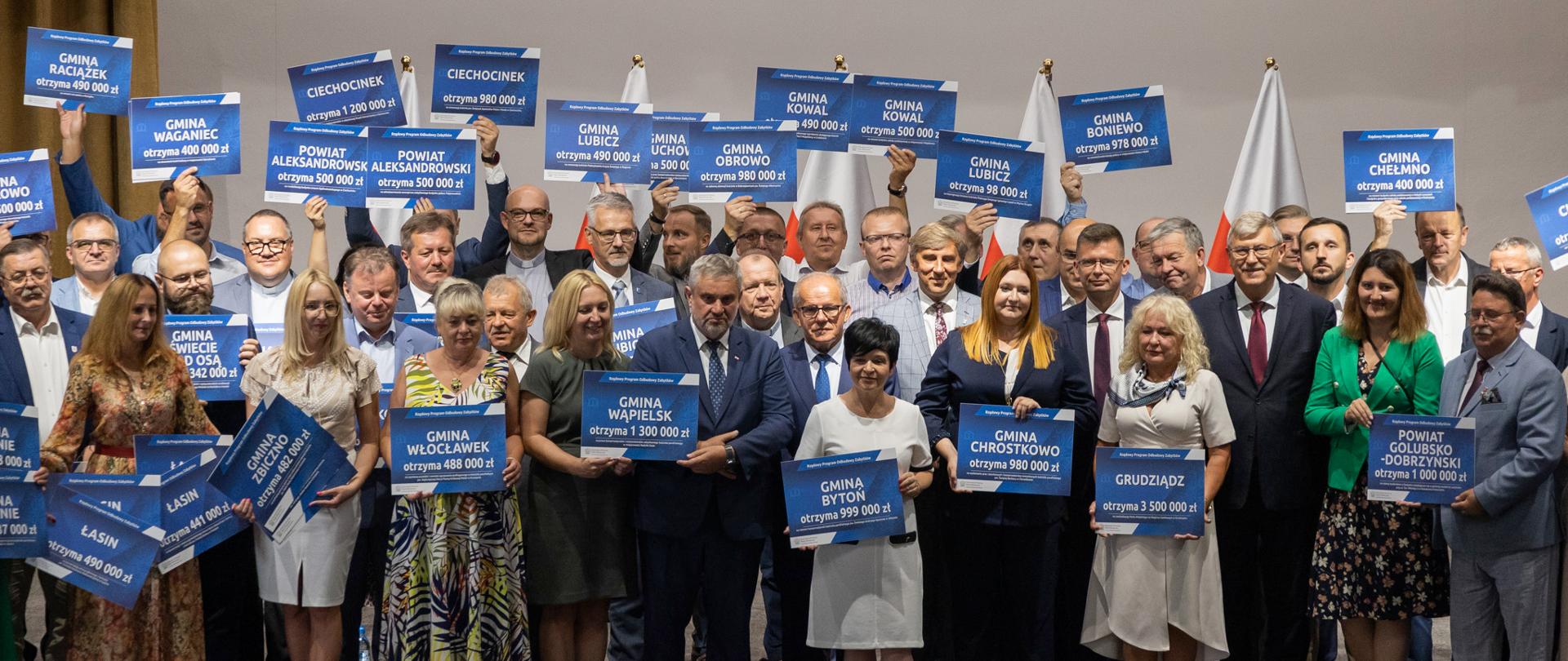 
Ludzie stojący na scenie w sali konferencyjnej
