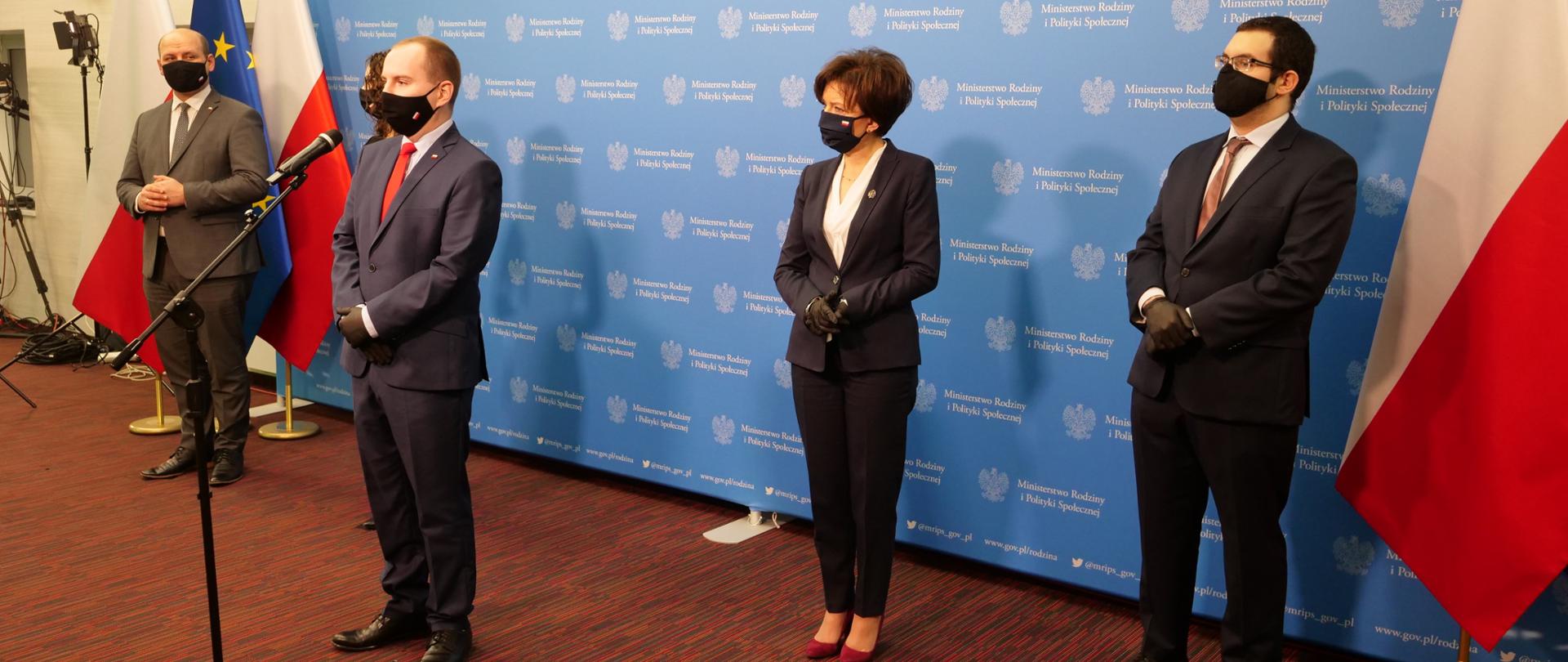 Uczestnicy konferencji prasowej - minister Adam Andruszkiewicz stoi przed mikrofonem, pozostali za nim - na tle ścianki konferencyjnej.