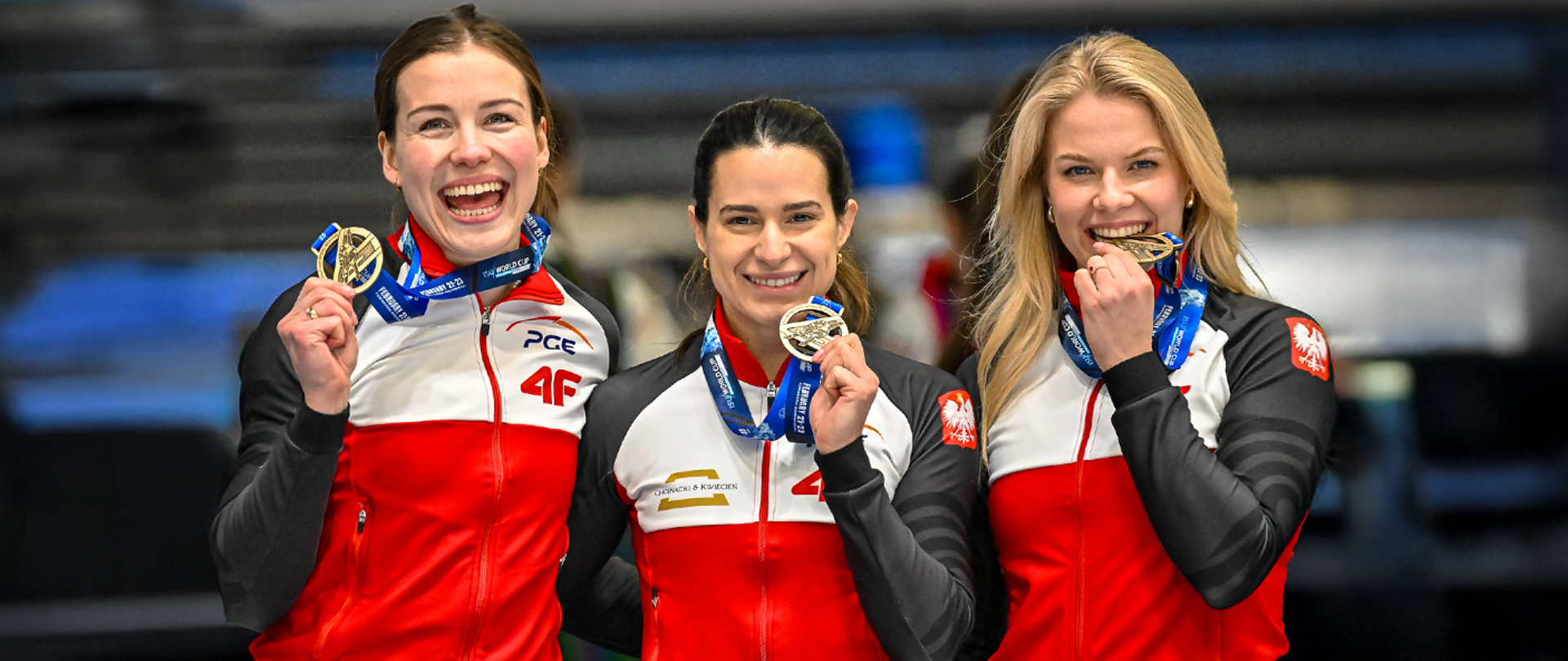 Polskie panczenistki ze złotymi medalami w Pucharze Świata w łyżwiarstwie szybkim z medalami w dłoniach na tle trybun