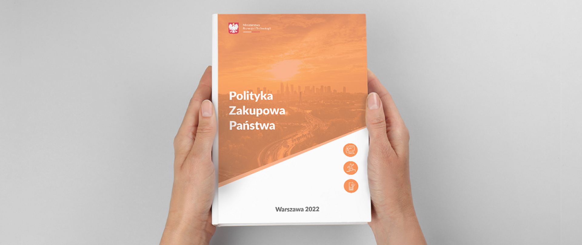 Męskie dłonie trzymające książkę z napisem Polityka zakupowa państwa