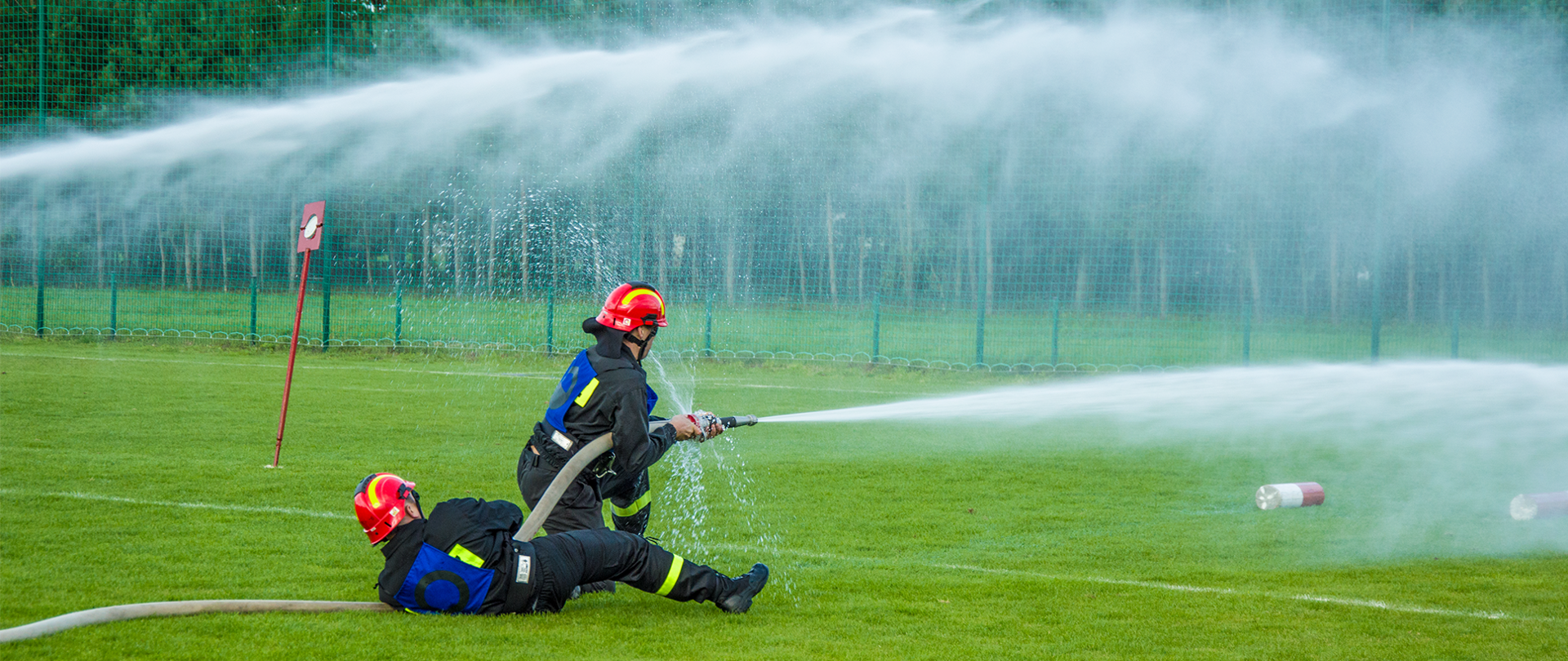 Zdjęcie przedstawia strażaków podczas Powiatowych Zawodów Sportowo - Pożarniczych.
W tle stadion sportowy.
