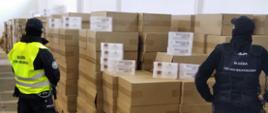 Funkcjonariusze KAS stoją przy kartonowych pudłach