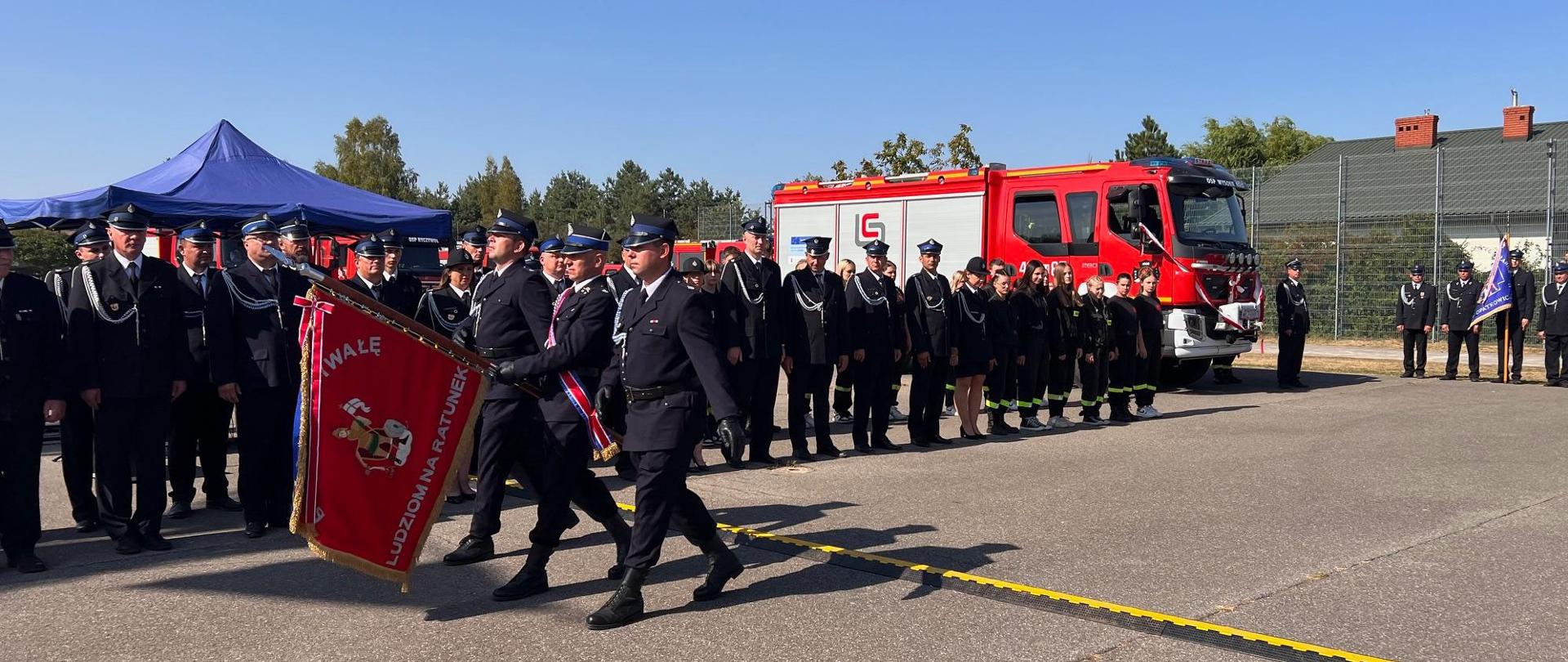 Poczet sztandarowy na tle pododdziału pożarniczego