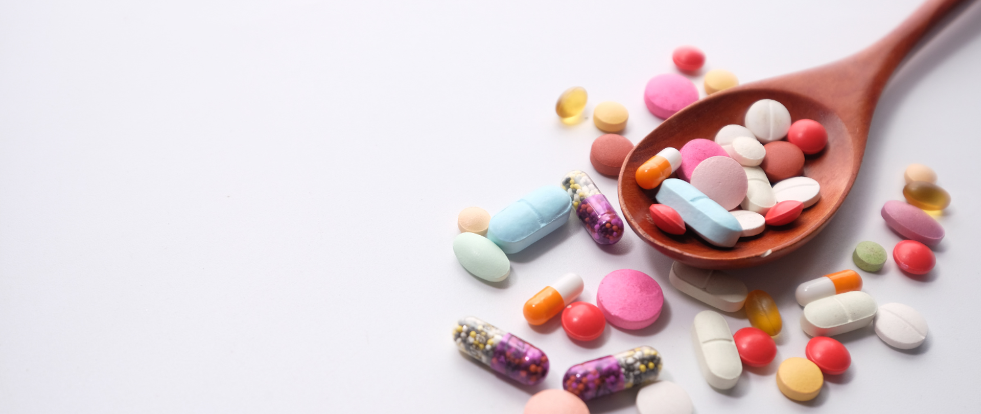 wiele kolorowych tabletek na łyżce