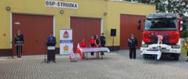 Zdjęcie przedstawia czytającego list gratulacyjny od wojewody lubuskiego Pana Karola Zieleńskiego na tle jednostki Ochotniczej Straży Pożarnej w Strużce.