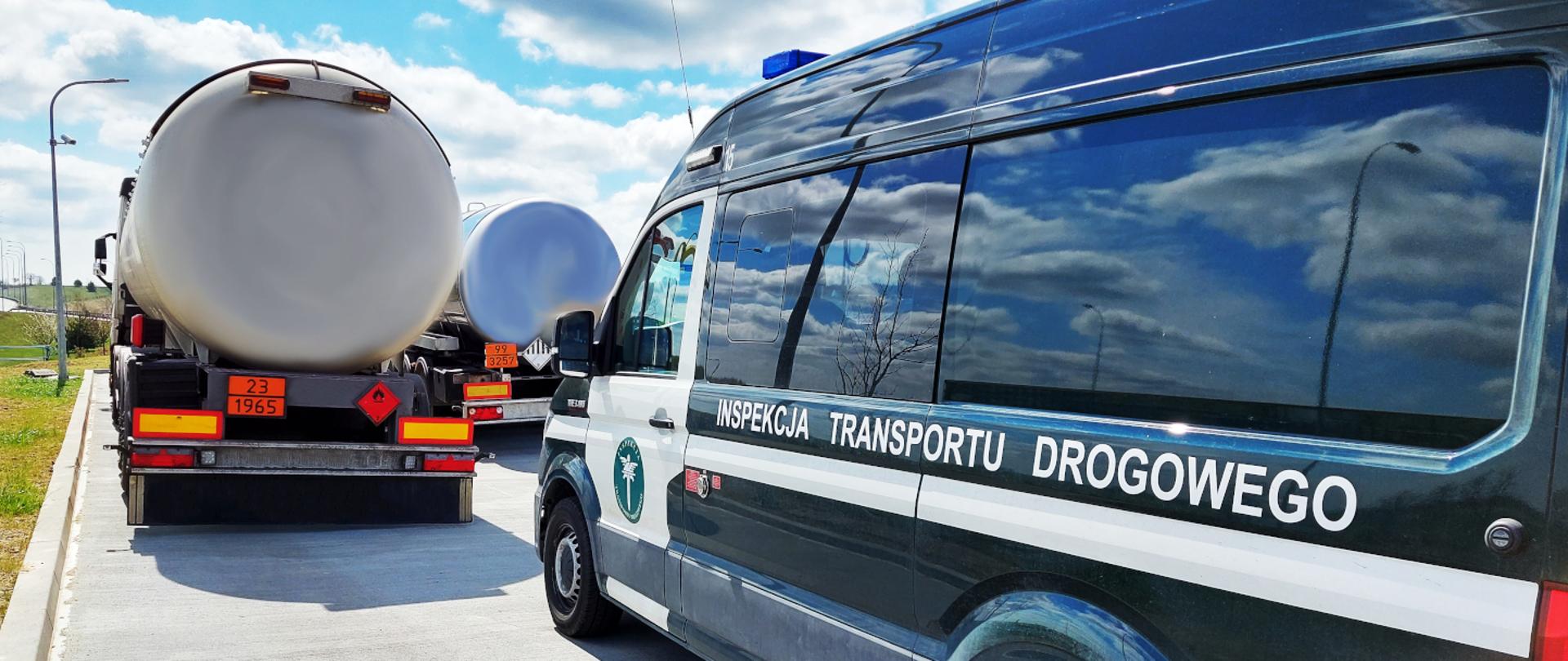Samochód ciężarowy zatrzymany do kontroli przez inspektorów pomorskiej Inspekcji Transportu Drogowego. Na zdjęciu po prawej inspekcyjny furgon, a przed nim, po lewej samochód ciężarowy skontrolowany przez inspektorów ITD. W oddali inna ciężarówka.