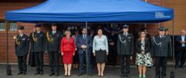 Na zdjęciu widoczna trybuna honorowa oraz zaproszeni goście strażacy PSP, OSP, parlamentarzyści, samorządowcy pod niebieskim namiotem. 