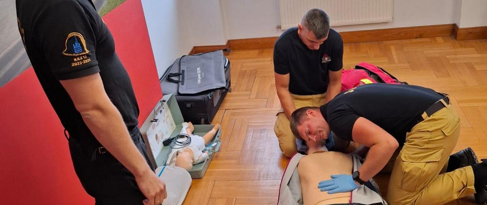 Strażacy ćwiczą udzielanie pierwszej pomocy na manekinie.