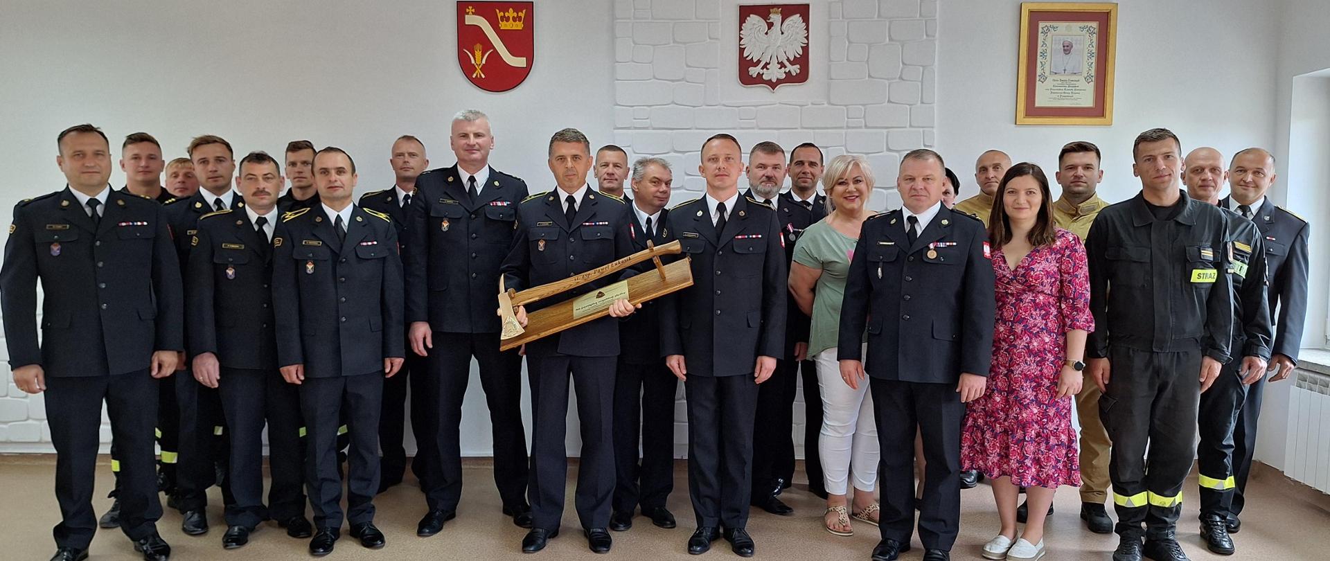 Strażacy stoją w mundurach. Pozują do zdjęcia.