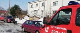 Na tle ośrodka zdrowia w Narwi czerwony strażacki samochód z napisem OSP Trześcianka